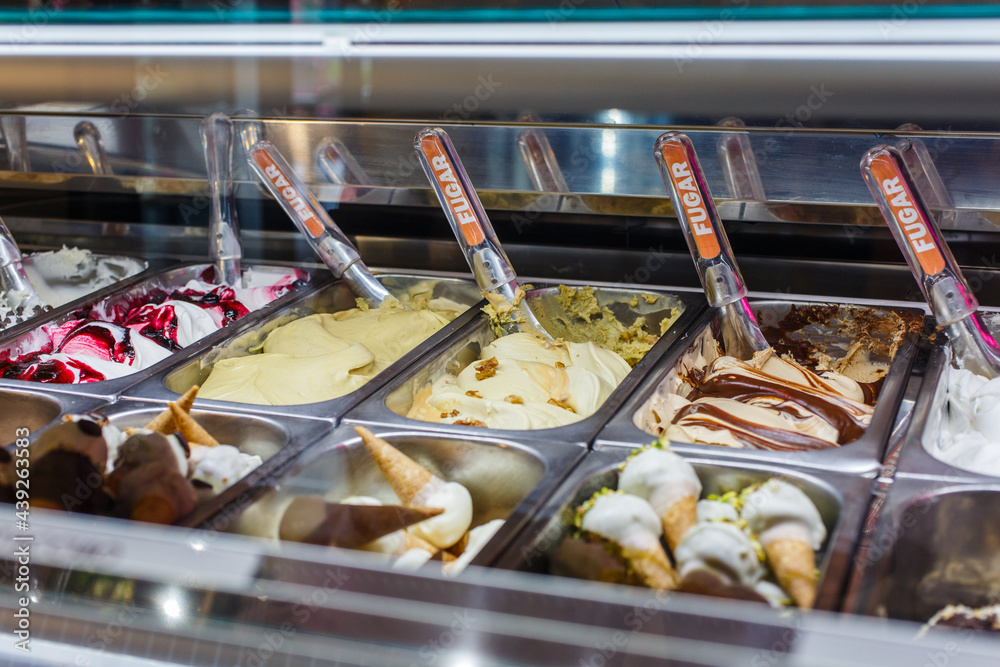 Bancone di una gelateria con diversi tipi di gusti di gelato