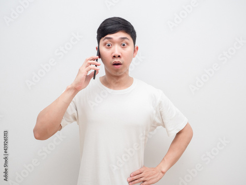 Asian man holding cell phone shocked face look at camera on white background