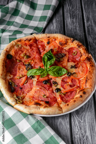 Fresh italian pizza with salami and black olives. Traditional Italian pizza recipe, Italian cuisine.