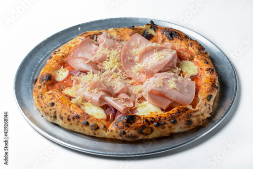 Pizza Prosciutto served on a metal tray over white background.