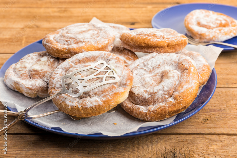 Spanish Ensaimadas spiral pastry on rustic table Spanish Ensaimadas spiral pastry on rustic table