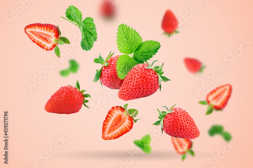 Strawberry berries levitating on a pink background. Horizontal. Selective focus.