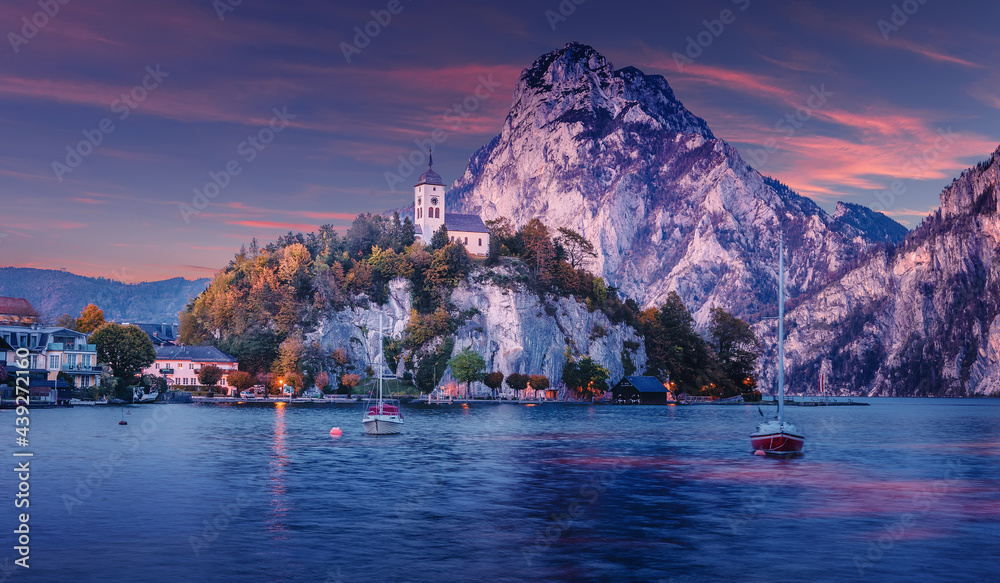 Fototapeta premium Scenic image of Stunning nature in Austrian alps. Amazing Autumn Landscape with Chapel on a rock over the Traunsee lake in the Alps of Austria. incredible natural background. Travel adventure concept