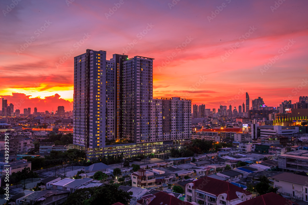 Naklejka premium The high angle background of the city view with the secret light of the evening, blurring of night lights, showing the distribution of condominiums, dense homes in the capital community