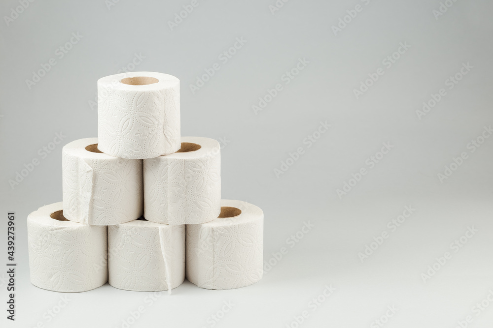 A Pyramid of Toilet Paper Rolls on Gray Background A Pyramid of Toilet Paper Rolls on Gray Background