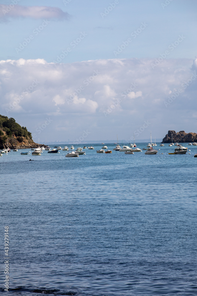 Fishing boats and yachts moored in the bay at high tide in Cancale, famous oysters production town. Brittany, France,