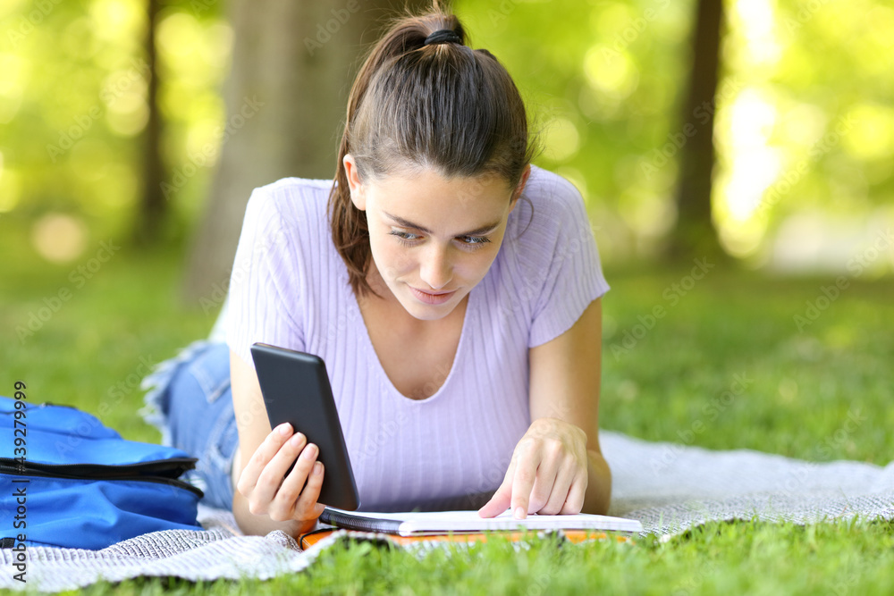 Student learning comparing notes with phone content Student learning comparing notes with phone content