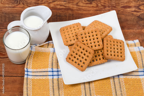 Flat sugar cookies and milk on rustic table, top view