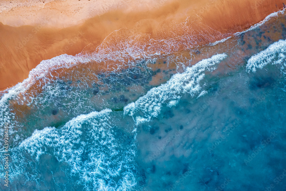 Concept summer sunny travel image. Turquoise water with wave with sand beach background from aerial top view