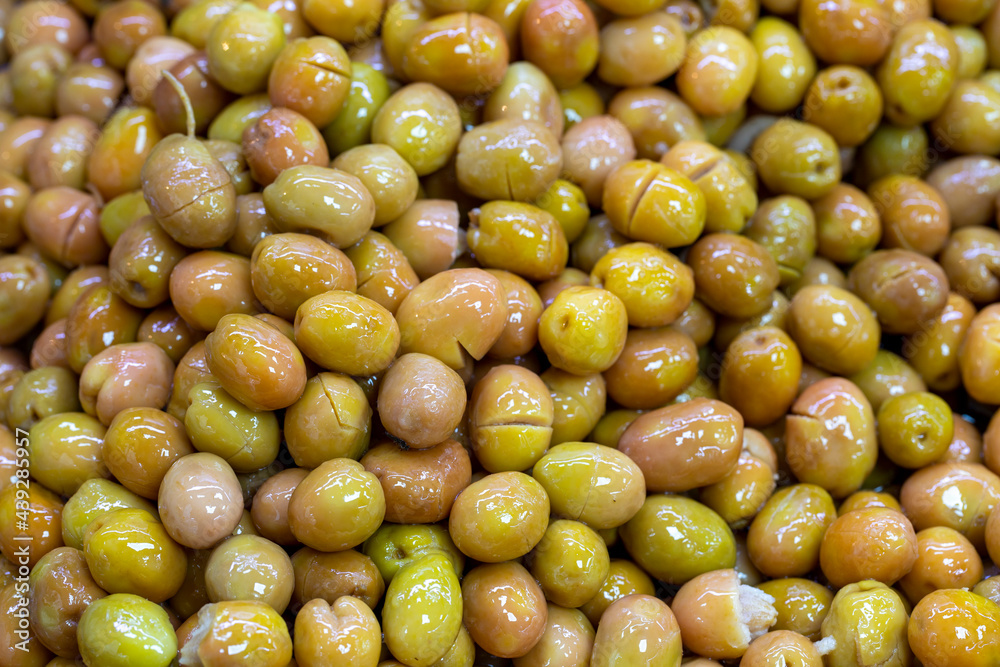 Scratched green olives. Close up. Green olives as background texture Scratched green olives. Close up. Green olives as background texture