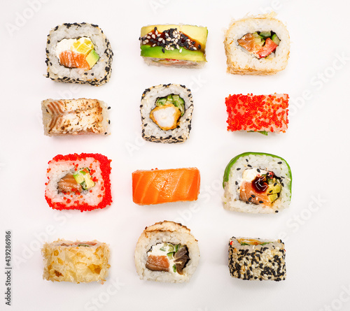 various sushi on white background, top view. maki sushi with seafood, salmon, shrimp, avocado and cucumber