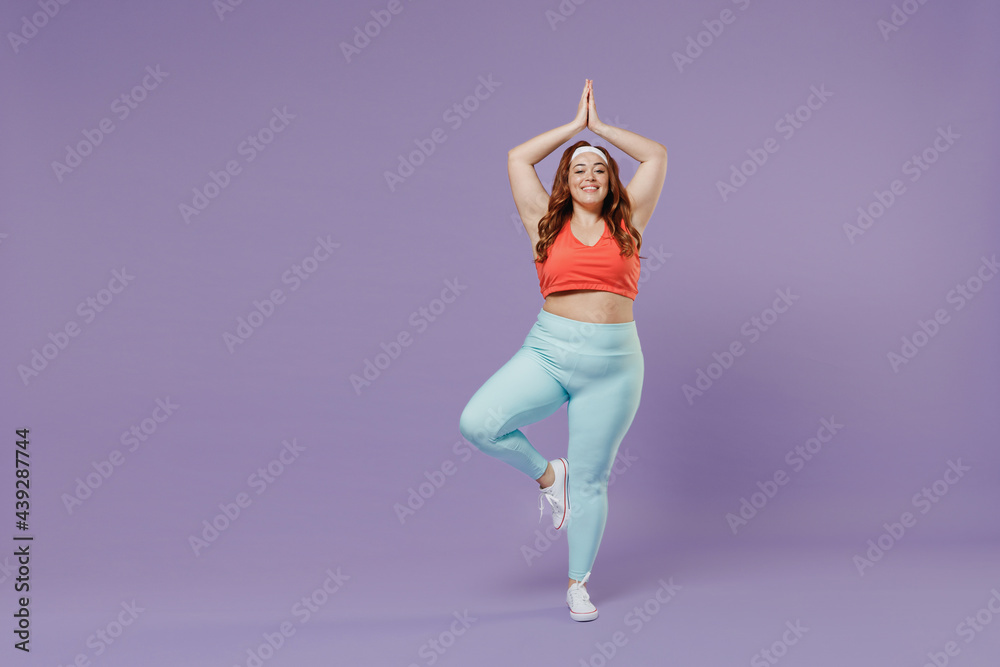 Full length happy young chubby overweight plus size big fat fit woman wear red top warm up training spreading hands in yoga om gesture meditate isolated on purple background gym Workout sport concept