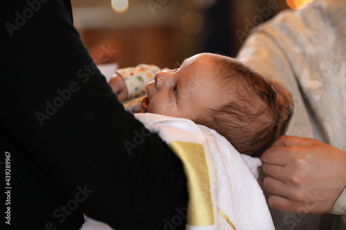 Obraz na plátně Man holding adorable baby in church during baptism ceremony, closeup