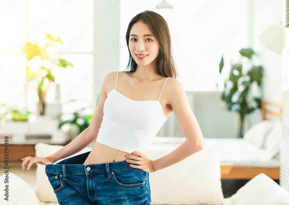 A young woman succeeded in losing weight. She wore large-size jeans a long time ago, showed her figure very confidently, and was in a very happy mood.