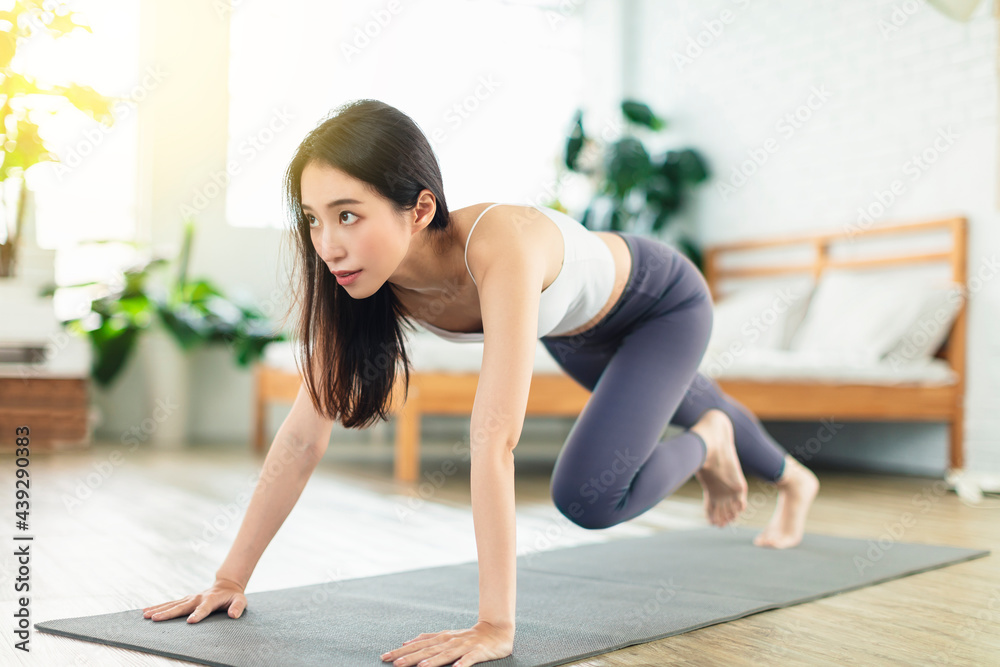 young woman, wearing casual sports clothing, exercises at home every day young woman, wearing casual sports clothing, exercises at home every day
