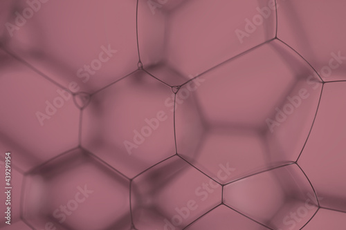 Extreme closeup of artistic geometric patterns  created by soap bubbles with light effects on pink  background.