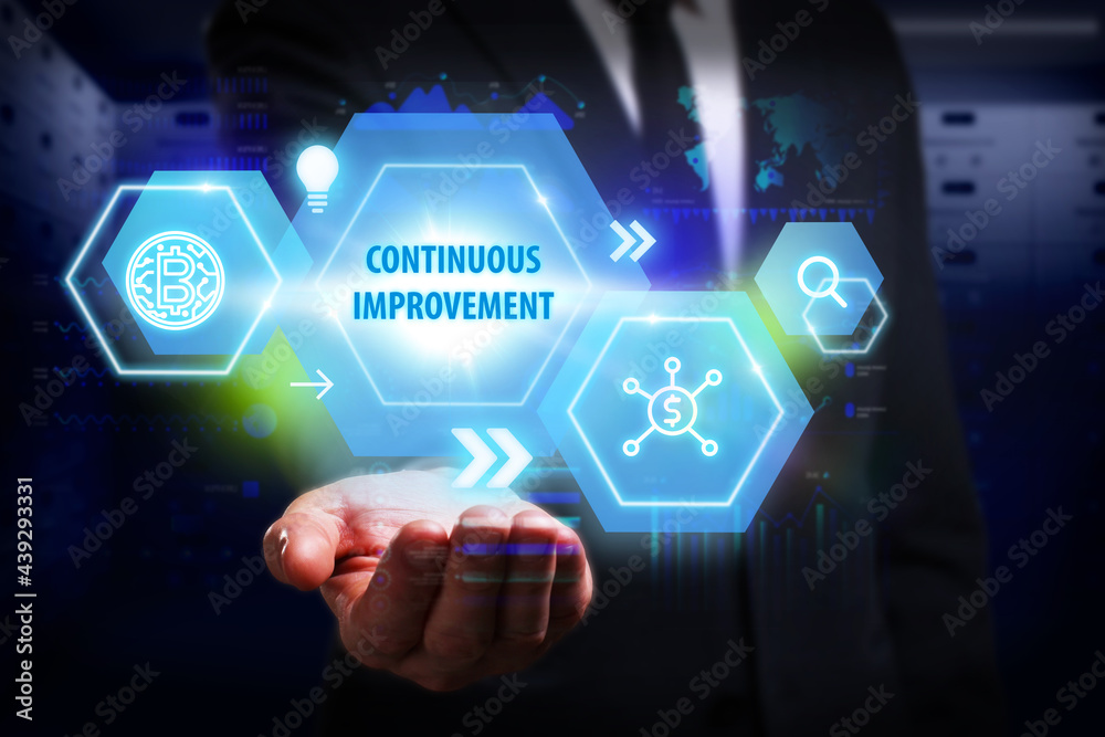 Business, Technology, Internet and network concept. Young businessman working on a virtual screen of the future and sees the inscription: Continuous improvement Business, Technology, Internet and network concept. Young businessman working on a virtual screen of the future and sees the inscription: Continuous improvement
