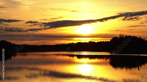 River reflections of clouds in a golden sky drifting past partial solar eclipse. photo