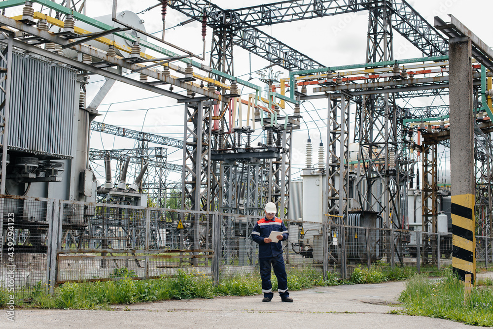 Fototapeta premium The energy engineer inspects the equipment of the substation. Power engineering. Industry