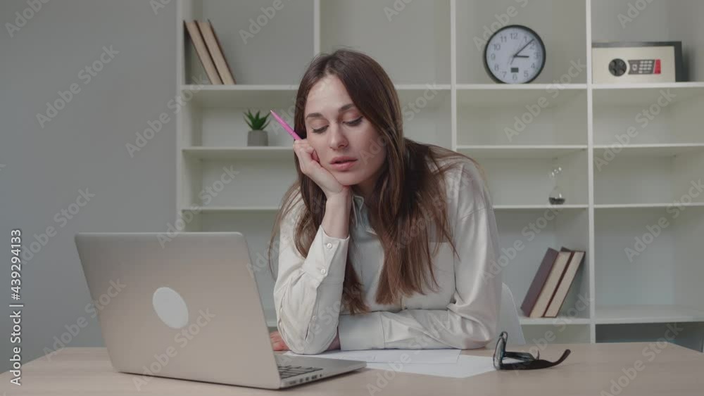 Businesswoman in sand-colored shirt laughing is in correspondence on a computer ag at office having fun alone