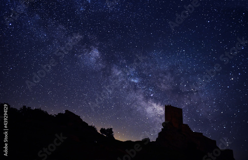 the milky way and the stars next to a castle