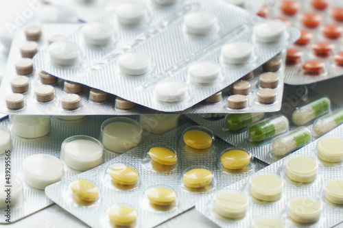 Overall view of pharmaceutical tablets and capsules in packages in assortment. Tablets in a blister