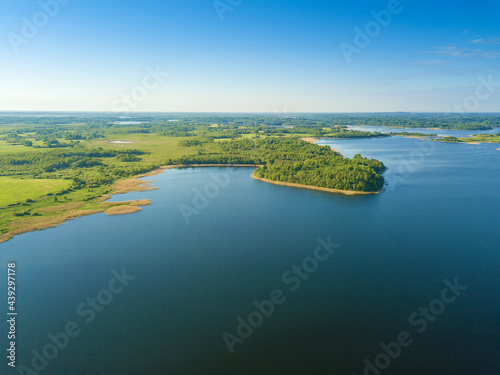 Beautiful aerial landscape on the lake with a drone. Many lake islands covered with forests  fields on a sunny day
