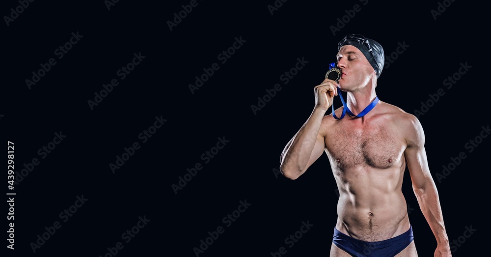 Composition of male swimmer kissing medal with copy space isolated on black background