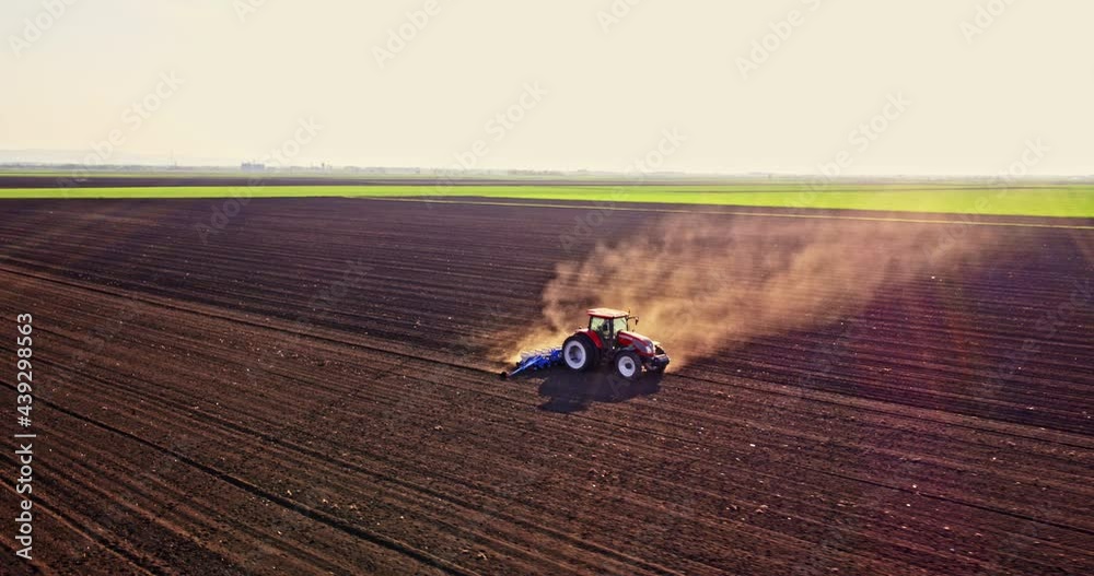 Farmer in tractor seeding corn on agricultural field