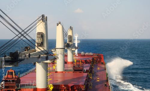 Bulk carrier with cranes during sea passage