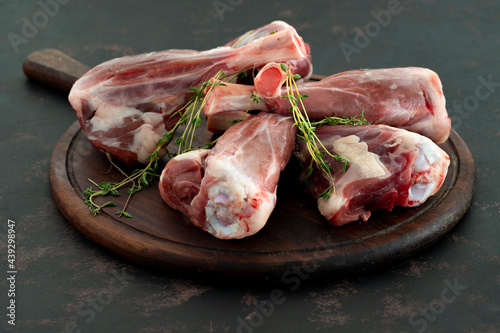 raw lamb shank on dark background
