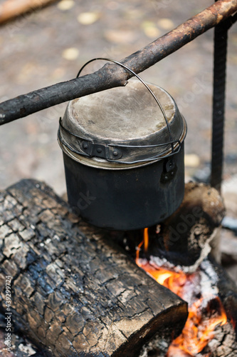 Camp fire, cooking dinner outdoors at the nature, pot over bonfire