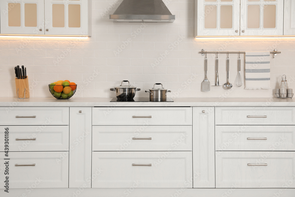 Fototapeta premium Modern kitchen interior with stylish white furniture