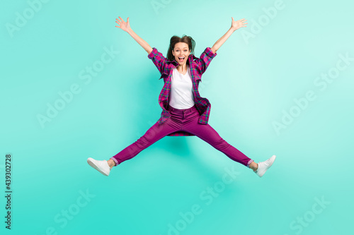 Full length photo of cool young lady jump wear shirt trousers sneakers isolated on vivid teal color background