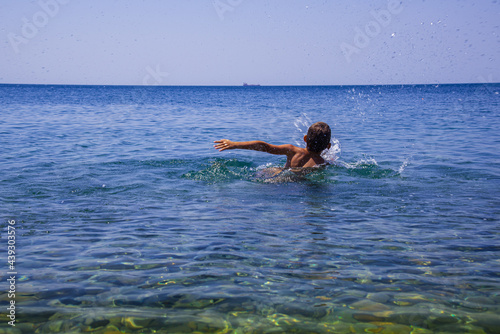 Boy learning to swim in the sea. Summer holiday on the sea. Concept of relaxation and a healthy lifestyle