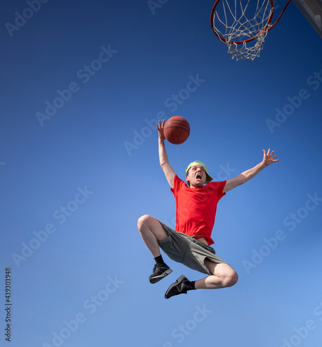 Crazy boy  having fun laughing and playing basketball © Neftali