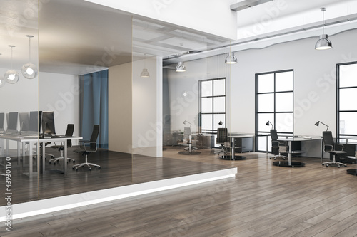 Modern sunny spacious office hall with minimalistic interior design, huge windows, glossy wooden floor, stylish furniture and separate stage with workspace and transparent glass walls