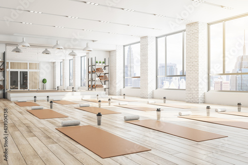 Fototapeta Naklejka Na Ścianę i Meble -  Concrete yoga gym interior with equipment, daylight and wooden flooring. Healthy lifestyle concept. 3D Rendering.