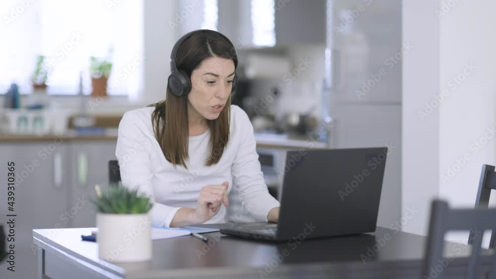 Woman with headphones making video call from home Woman with headphones making video call from home