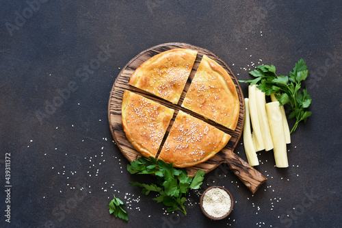 Khachapuri with suluguni cheese and cheese on a wooden board. Svehu view.