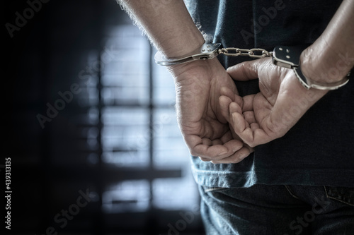 Foto Criminal wearing handcuffs in prison