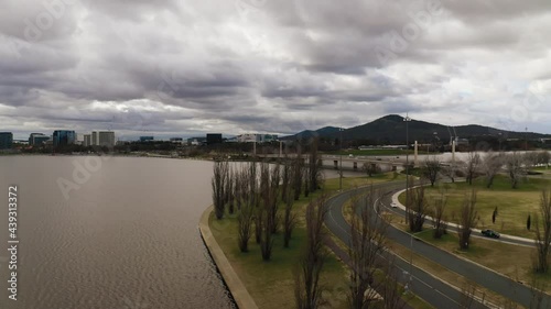 Wallpaper Mural Aerial drone shot flying over a lake next to tall trees with storm clouds above

Aerial drone shot flying over a lake next to tall trees with a mountain and city buildings in the background and storm  Torontodigital.ca
