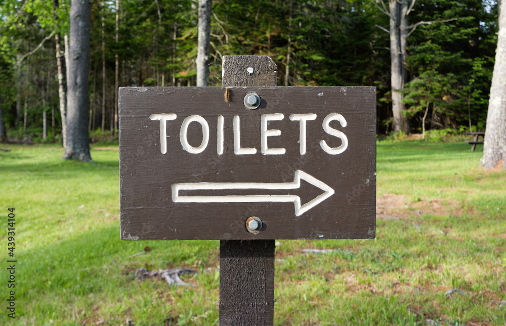 Wood sign designating the way to toilets Wood sign designating the way to toilets