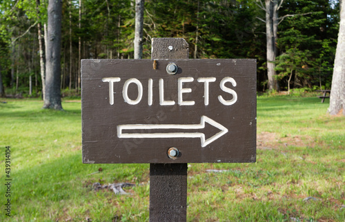 Wood sign designating the way to toilets