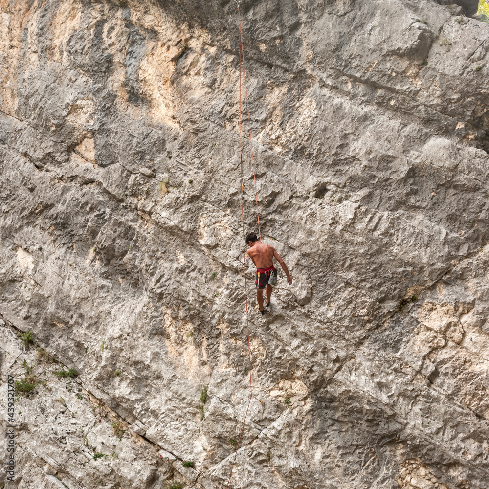climber climbs a rock face in abruzzo national park, italy, 