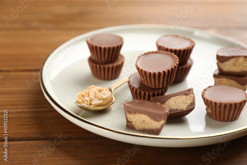 Cut and whole delicious peanut butter cups on wooden table