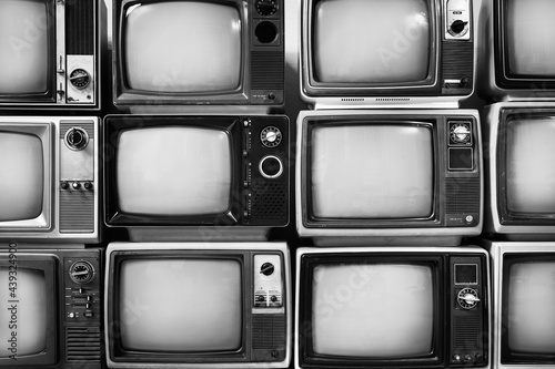 Retro black and white old televisions pile for background, close up