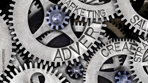 Group of rotating tooth wheels with Advertising sign imprinted on metal surface. Concept of Sales, Strategy, Creativity and Marketing. High quality 4k video.