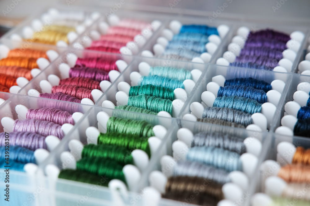 Close up of colorful embroidery floss bobbins in the box. Embroidery threads for handmade, crafts, hobbies. Close up of colorful embroidery floss bobbins in the box. Embroidery threads for handmade, crafts, hobbies.
