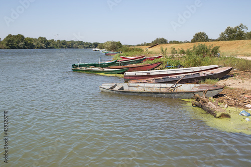 Fishing wooden boats on the Danube river shore in a windy weather condition. Summer landscape in the Balkans, Banatska Palanka, Serbia. photo